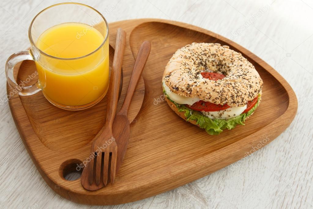 A sesame sandwich bun and a glass of juice