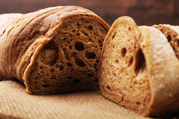 A loaf of crusty bread and a jar of oats — Stock Photo, Image