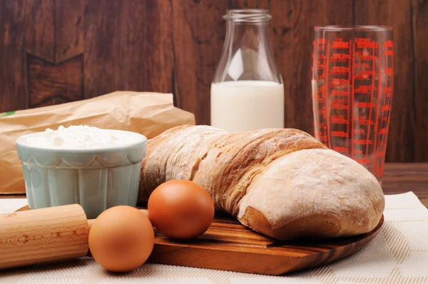 A loaf of crusty bread and a jar of oats — Stock Photo, Image