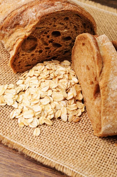 A loaf of crusty bread and a jar of oats — Stock Photo, Image