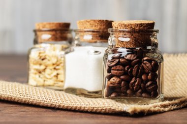 Üç kahve çekirdekleri, şeker ve yulaf dolu kavanoz