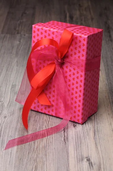 Bright pink gift box with red hearts — Stock Photo, Image