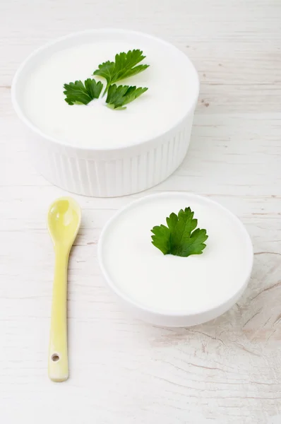 Two bowls topped with a parsley leaf and a spoon — Stock Photo, Image