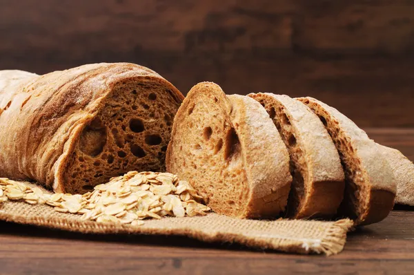 Cut bread and oats on a cloth — Stock Photo, Image