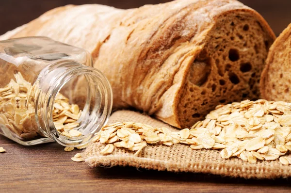 Oats and a loaf of bread on a napkin — Stock Photo, Image