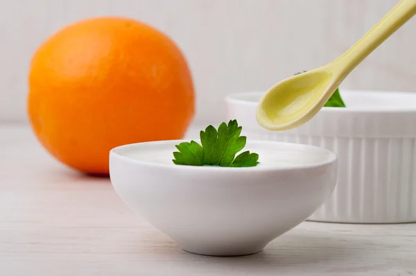 Two bowls with yogurt and an orange — Stock Photo, Image