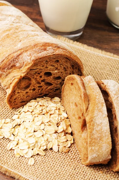 A loaf of bread and some oats on cloth — Stock Photo, Image