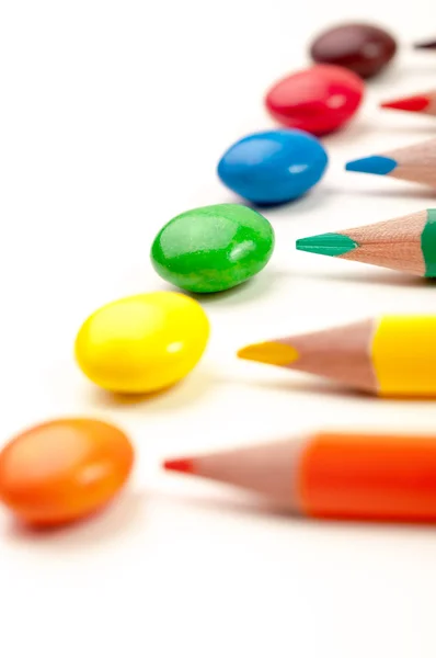 Pencils pointing at same color candies — Stock Photo, Image