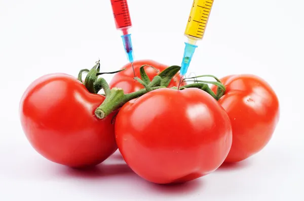 Tomatoes and colorful syringes — Stock Photo, Image