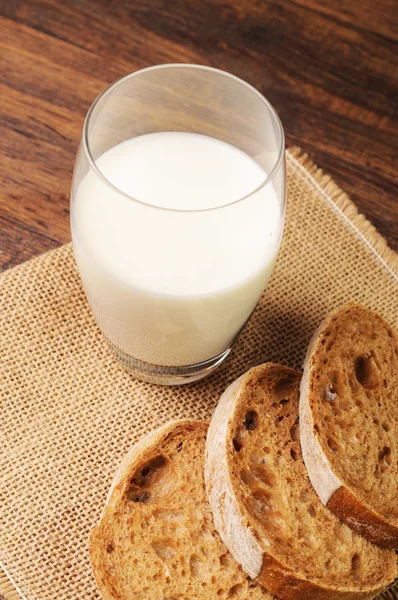 A glass of milk and bread on a napkin — Stock Photo, Image