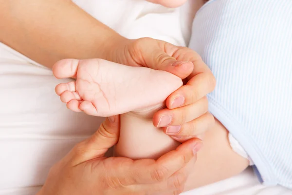 Frau hält sanft den Fuß des Neugeborenen — Stockfoto