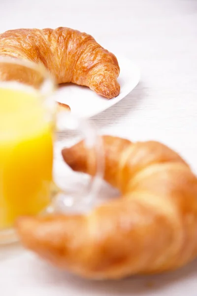 Croissanter och en kopp apelsinjuice — Stockfoto