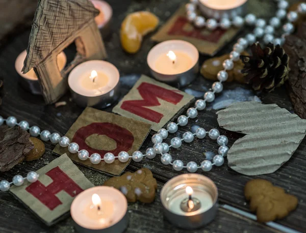 Te ljus, pepparkakor och teacandles runt bokstaven h o m e — Stockfoto