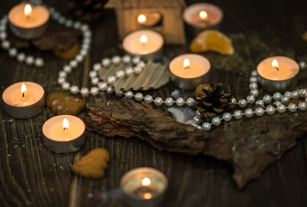 Tea candles and pearl beads on a rustic surface — Stock Photo, Image