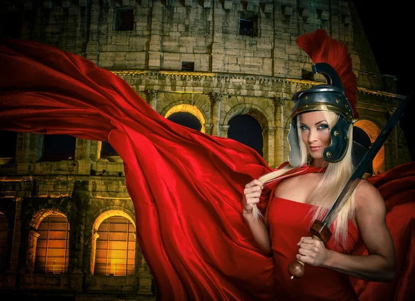 Fit blonde gladiatrix and Colossseum on the background — Stock Photo, Image
