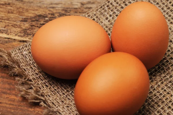 Três ovos em um pano de linho na mesa — Fotografia de Stock
