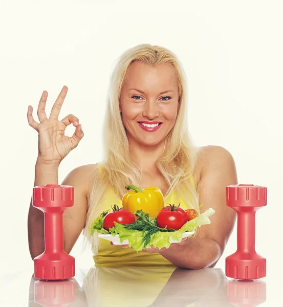 Mulher com comida e halteres — Fotografia de Stock