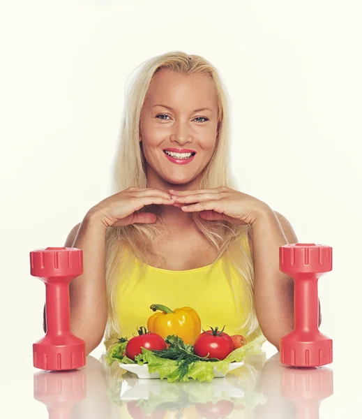 Woman with food and dumbbells — Stock Photo, Image