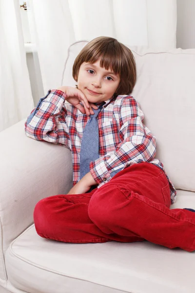 Menino no sofá branco — Fotografia de Stock