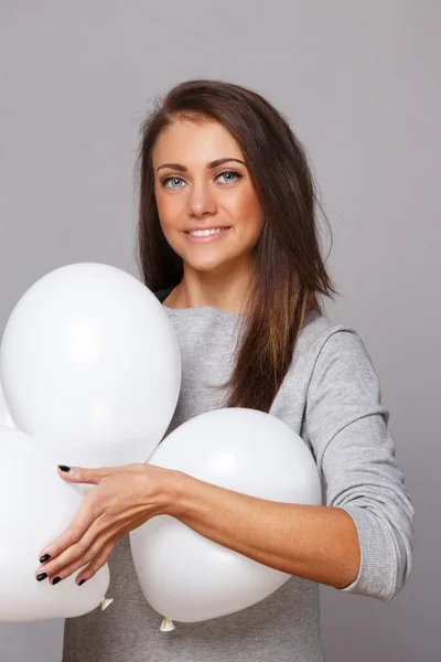 Mujer de camisa gris con globos blancos —  Fotos de Stock