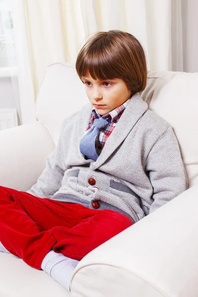 Мальчик на белом диване — стоковое фото
