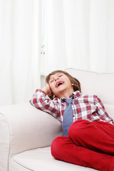 Niño en sofá blanco —  Fotos de Stock