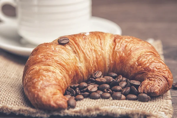 Croissant และเมล็ดกาแฟ — ภาพถ่ายสต็อก