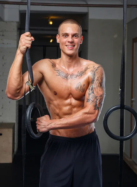 Sonriente atleta tatuado posando en un gimnasio — Foto de Stock