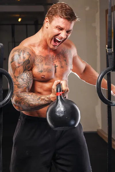 Tattooed athlete lifting weights — Stock Photo, Image