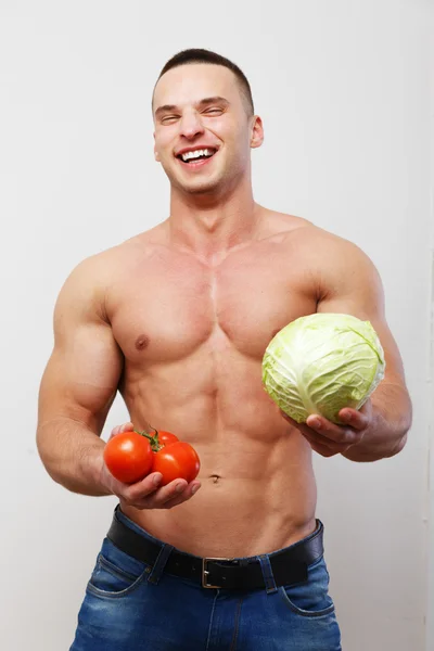 Topless guy holding tomatoes and a cabbage — Stock Photo, Image