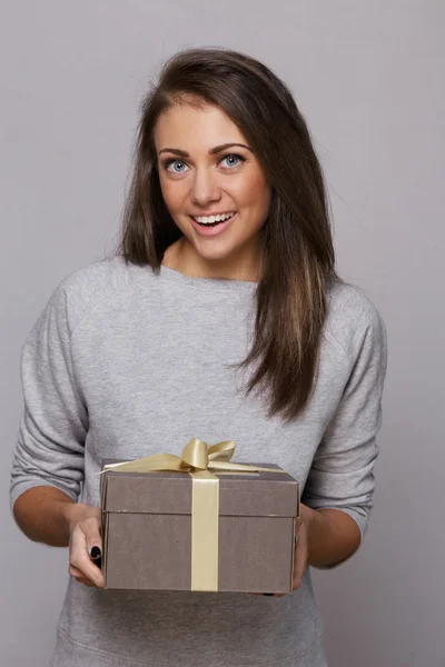 Menina surpresa com uma caixa de presente marrom — Fotografia de Stock