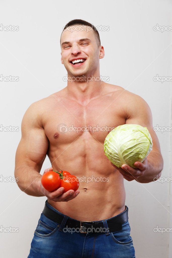 Topless guy holding tomatoes and a cabbage