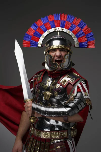 Screaming roman centurion with red cloak holding gladius — Stock Photo, Image