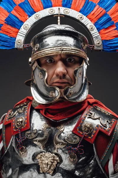 Roman centurion with plumed helmet staring at camera