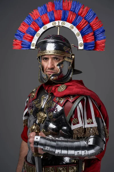 Guerreiro romano pensativo vestido com armadura de aço e manto vermelho — Fotografia de Stock