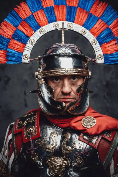 スタジオショットの恐怖ローマの兵士とともにカラフルな羽飾りヘルメット — ストック写真