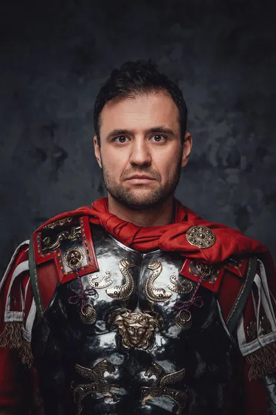 Römischer Krieger in Rüstung posiert vor dunklem Hintergrund — Stockfoto