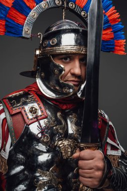 Gri üzerine izole edilmiş kılıçla poz veren Roma lejyoneri