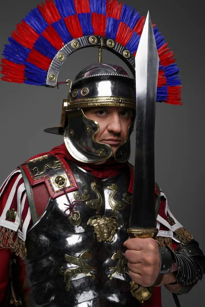 Romeinse legionair poserend met zwaard geïsoleerd op grijs — Stockfoto
