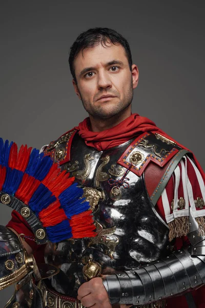 Сильный римский центурион со шлемом, изолированным на сером — стоковое фото