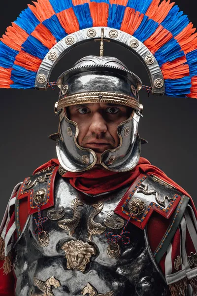 Roman centurion with plumed helmet staring at camera