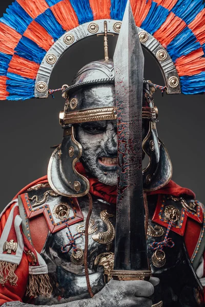 灰色の背景に血の剣を持つ死んだローマの兵士 — ストック写真