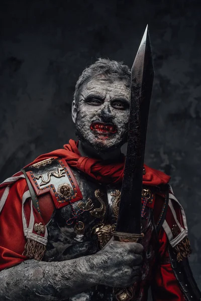 Griezelige centurion zombie met gladius tegen donkere achtergrond — Stockfoto