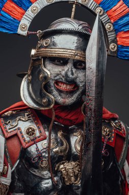 Gülümseyen zombi yüzbaşısı gri üzerine izole edilmiş kameraya bakıyor.