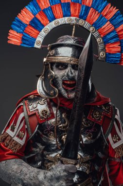 Gri üzerine izole edilmiş gladyatörle poz veren zalim zombi yüzbaşısı.