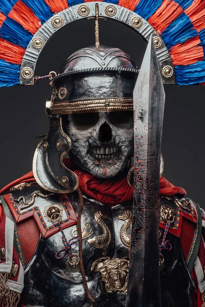 Dood Romeins soldaat met bloederig zwaard tegen grijze achtergrond — Stockfoto
