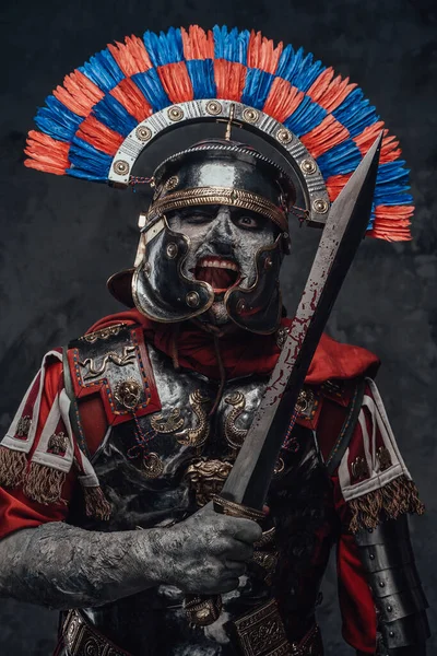 Моторошний легіонер з зануреним шоломом, що тримає короткий меч — стокове фото