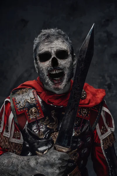 Centurion zombie z przerażającą twarz trzymając miecz na ciemnym tle — Zdjęcie stockowe