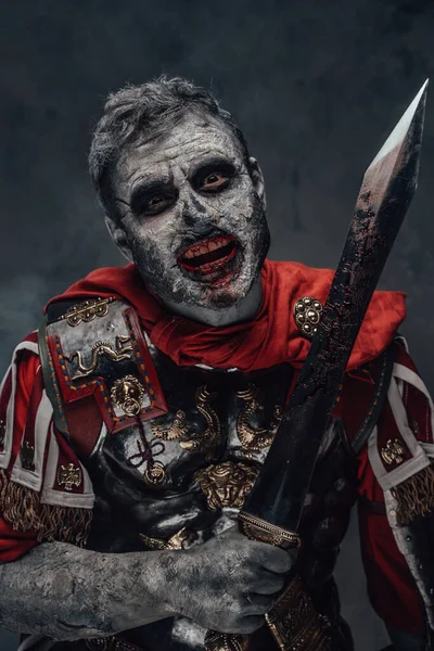Centurion zombie met eng gezicht met zwaard tegen donkere achtergrond — Stockfoto