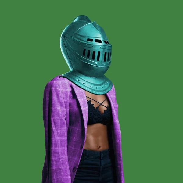 Stylish black woman with knight helmet against green background — Stock Photo, Image